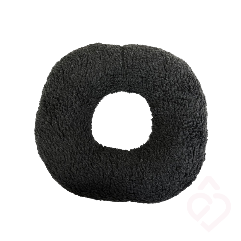 Almofada anti-escaras em formato donut, com abertura central para alívio da pressão.