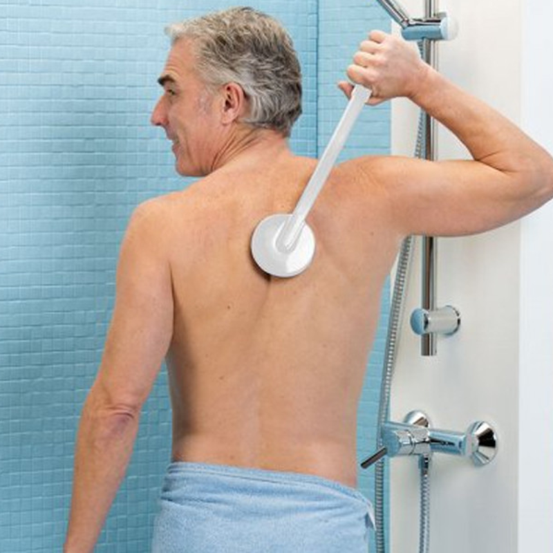Homem a utilizar o aplicador de creme de cabo comprido nas costas, facilitando a aplicação autónoma de produtos em zonas difíceis de alcançar.