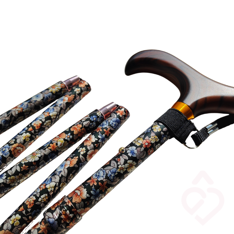 Bengala dobrável com padrão floral e cordão, compacta quando dobrada para facilitar o transporte e a arrumação.