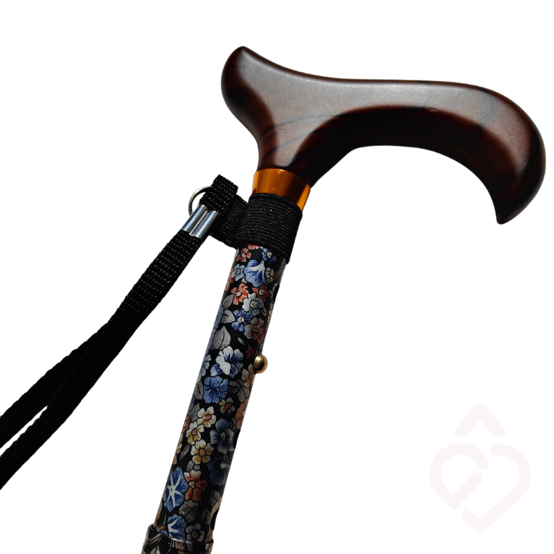 Detalhe da parte superior de uma bengala com padrão floral, cabo em tom de madeira e cordão