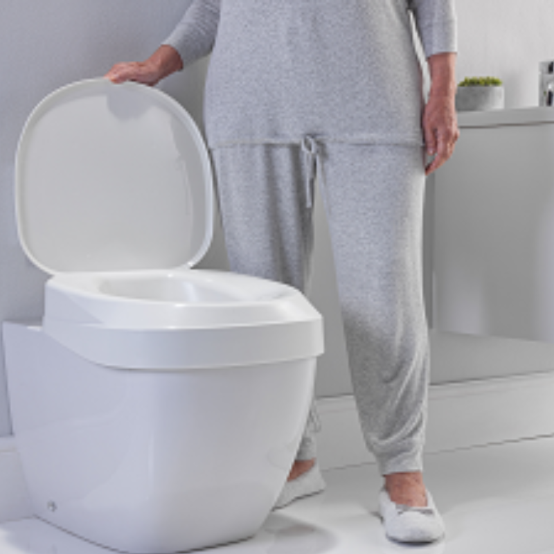 Elevador de sanita ergonómico branco, concebido para aumentar a altura da sanita e facilitar o sentar e o levantar. Proporciona maior conforto, segurança e autonomia a pessoas com mobilidade reduzida.