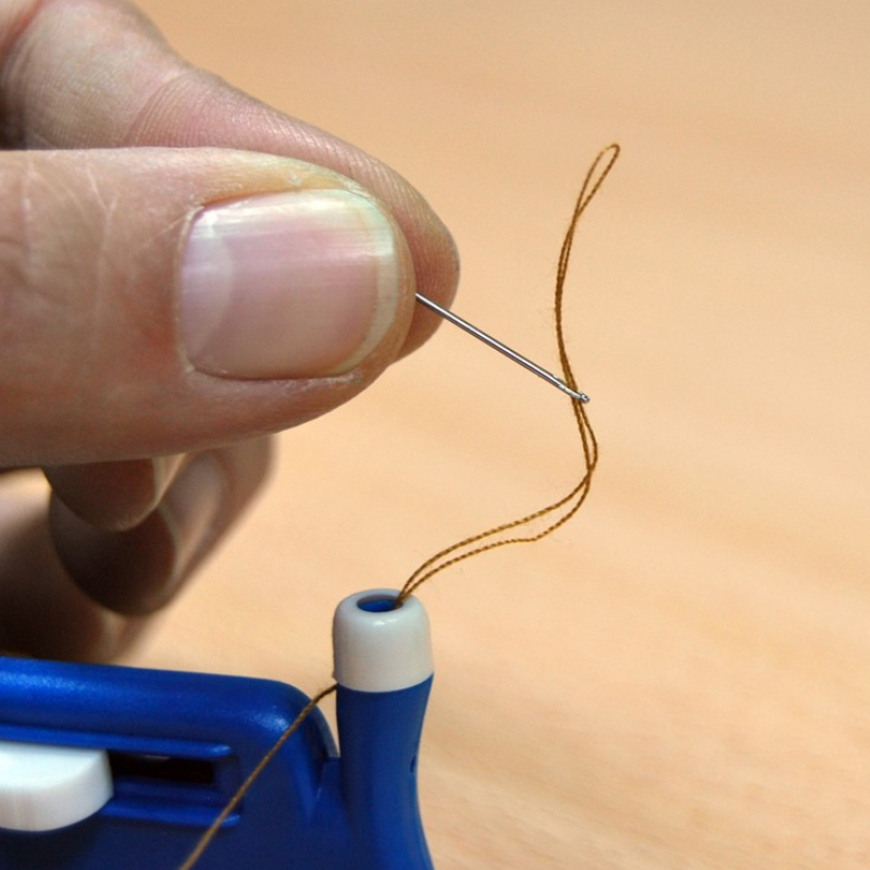 Agulha com linha corretamente enfiada com o auxílio do Infila, demonstrando um resultado rápido e simples que facilita a costura e promove maior autonomia.