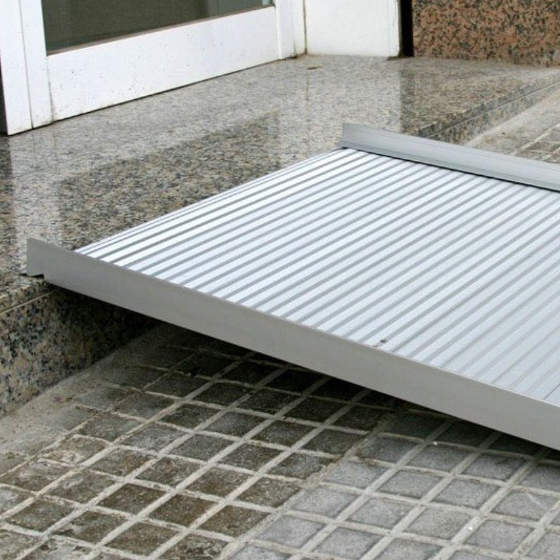 Rampa dobrável em alumínio com superfície antiderrapante para facilitar a passagem de cadeiras de rodas e scooters.