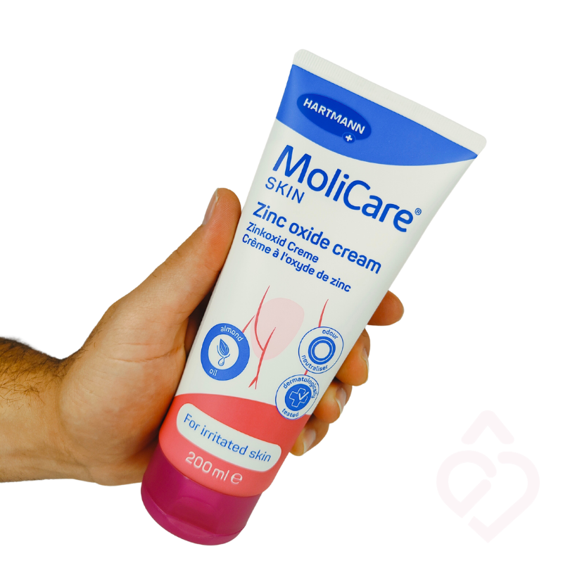 Embalagem de MoliCare Skin Creme de Óxido de Zinco 200 ml na mão, creme de cuidado e proteção da pele irritada.