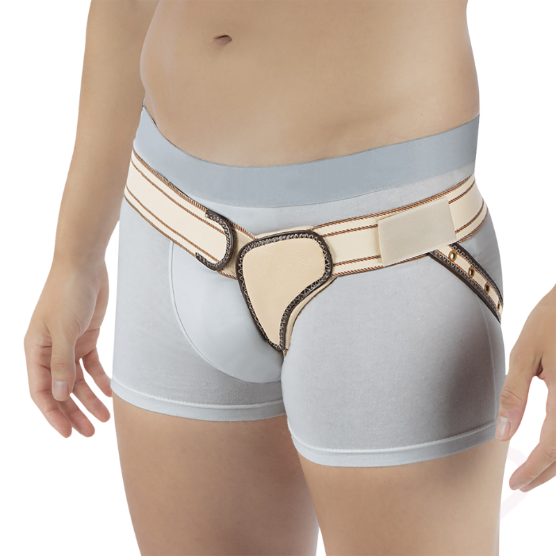 Funda reforçada para hérnia inguinal esquerda Orliman IH-112, apresentada em utilização, com cinta elástica ajustável, almofada de compressão e tira de fixação. Proporciona suporte localizado na região inguinal esquerda, ajudando a aliviar o desconforto e a oferecer maior segurança e estabilidade durante as atividades diárias.